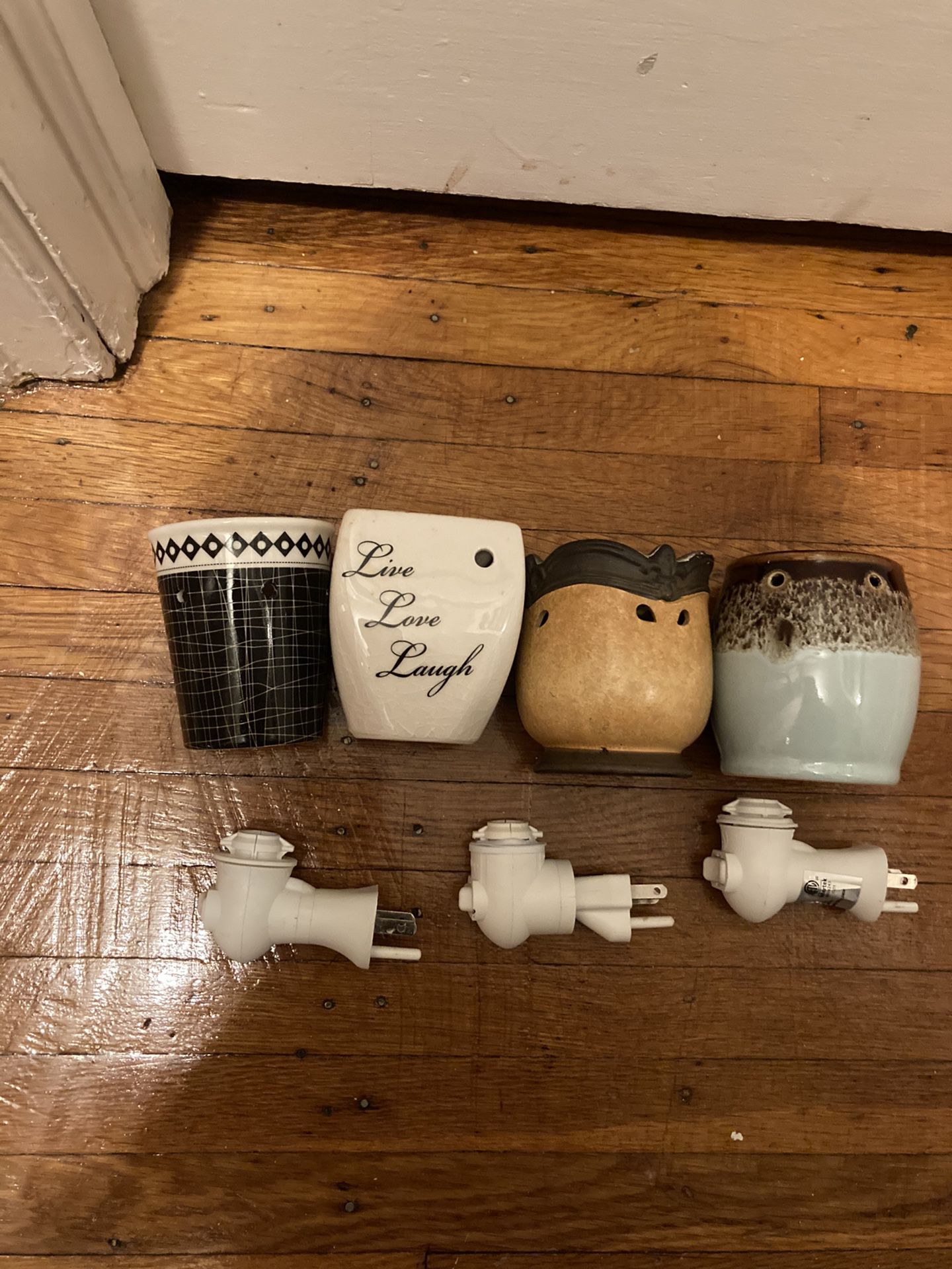 Four interchangeable Scentsy plug in wax warmers with three plugs