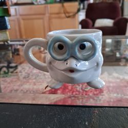 Vintage ceramic mug featuring a sculpted face wearing eyeglasses.