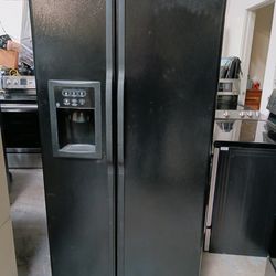 Refrigerator ge side by side in color black good condition no working ice maker only and 40 days warranty