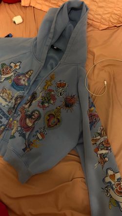 Real Righteous Zip-Up Hoodie – Baby Blue  Authentic Righteous zip-up hoodie in a baby blue colorway with detailed religious graphic artwork on the fro