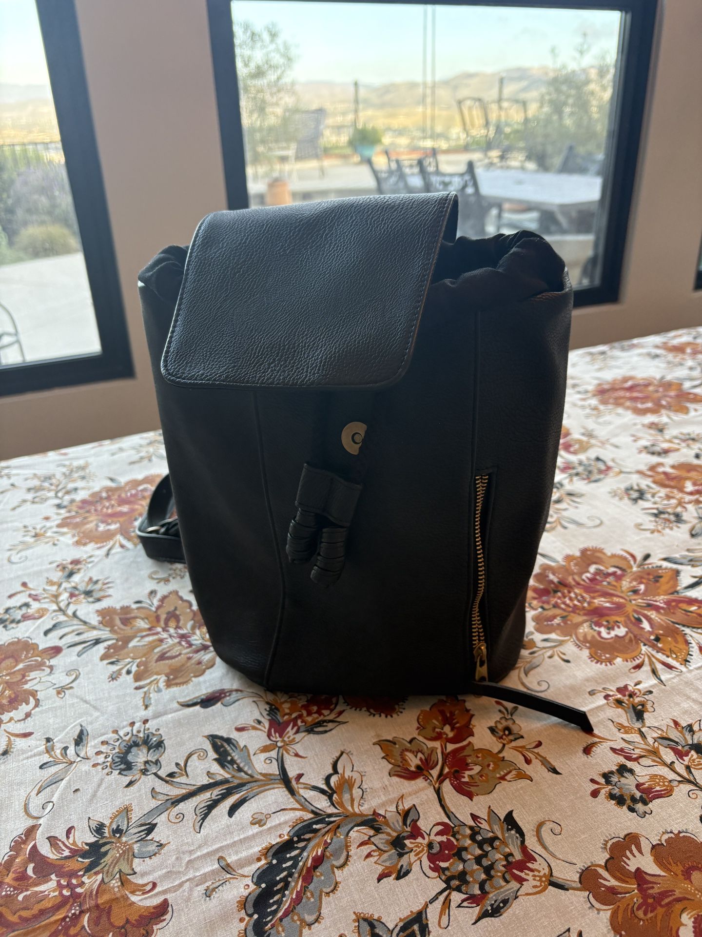 Black Universal Thread backpack with small side zipper pocket and pull-close front detail