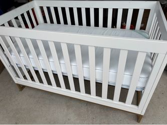White crib with gold metal base