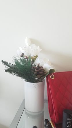 Christmas holiday decorations flowers and pine cone in white vase