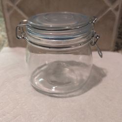 clear glass storage jar featuring a hinged clamp lid with a rubber seal to ensure an airtight closure.