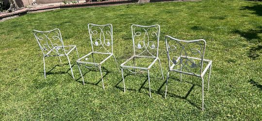 Four ornate metal chair frames