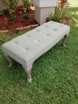 Beige French vintage tufted upholstered bedroom bench with button tuffing, nailhead trim and curved distressed wood legs. Have small bleached spot. Go