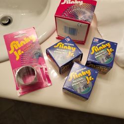 Vintage slinky's the original ones that were metal three boxes of the slinky juniors , one of the original large one and one of a junior in the packag