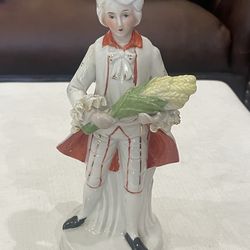 Porcelain figurine of a man holding corn, in 18th-century attire.