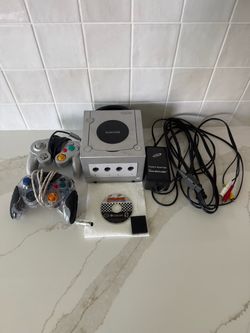 GameCube console with two controllers and Mario kart game