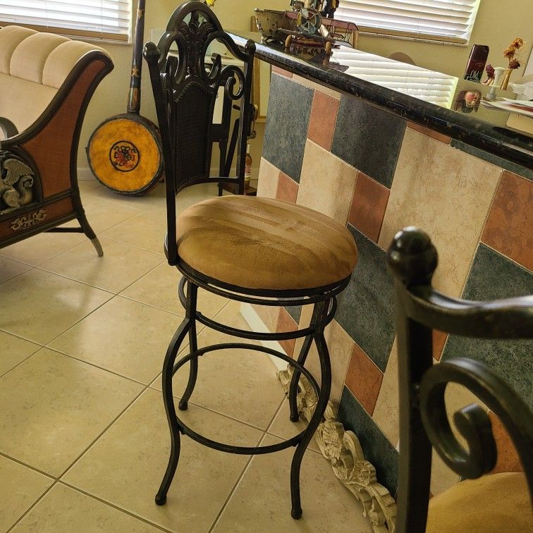 TWO WROUGHT IRON SWIVAL BAR STOOLS WITH TAN SUEDE  SEATS