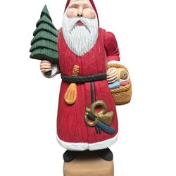 This is a hand-carved and painted folk art Santa Claus figurine, potentially.  The figurine is made of carved wood, likely basswood.  It is a vintage 