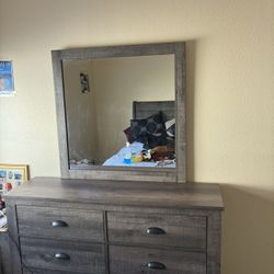 Bed Set And A Dresser With A Mirror 