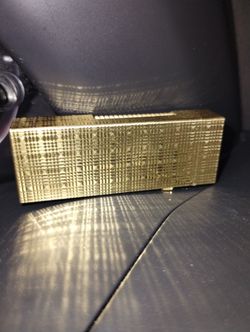 dunhill lighter crafted in gold-plated brass, meticulously engraved with a delicate pattern inspired by the texture of silk moiré, and bearing the