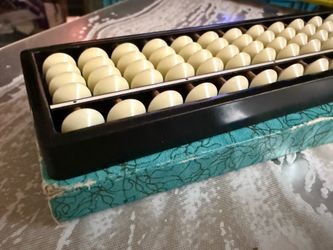 Vintage 13-Column Japanese Soroban Abacus   Vintage Japanese soroban abacus is constructed with a black frame and cream-colored plastic beads. This 13