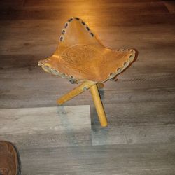 vintage hand-tooled leather saddle stool with folding tripod legs. 