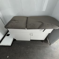 Medical clinic exam table with storage cabinets