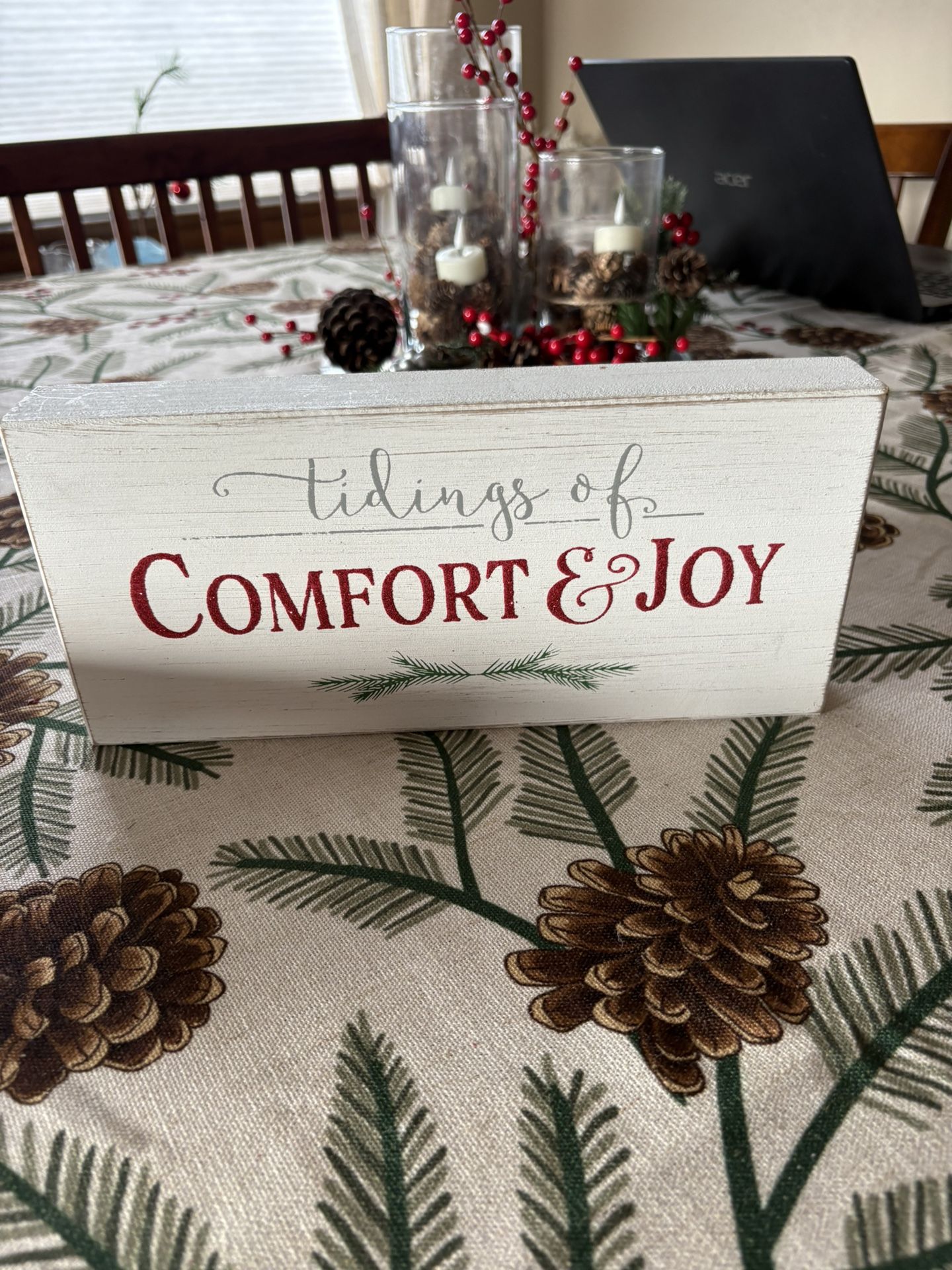 rustic wooden sign featuring the text "tidings of COMFORT & JOY