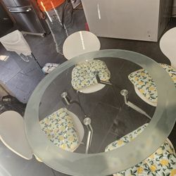 Glass dining table with 4 chairsStylish round glass dining table. Has a cool frosted edge and sturdy metal base. Comes with 4 white chairs. 