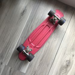 Pink penny board with blue wheels