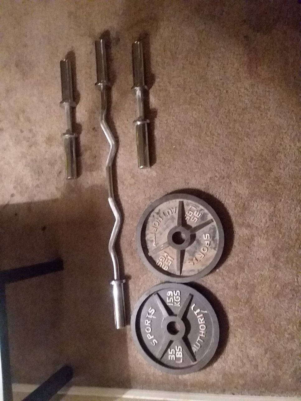 Olympic dumbbell and curling bar. Two 35 lb olympic weights (comes with end clamps)