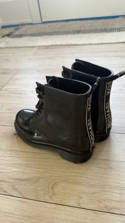 Michael Michael Kors Tavie Rain Booties in black, featuring a glossy finish and a white logo tape detail on the heel size 6