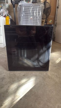 Small black mini fridge with a glass door, blue LED light from inside
