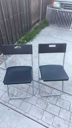 2 black sitting foldable chairs