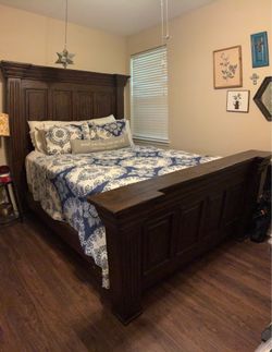 Large solid wood queen bed frame with headboard, footboard, and runners