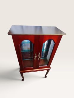 Cherry-finished wood curio cabinet with Queen Anne legs and glass doors