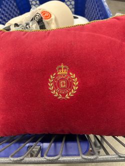 featuring a gold embroidered crown crest and twisted gold rope trim. According to Poshmark, it is a “Vintage Chaps Ralph Lauren Red Velvet Pillow Gold