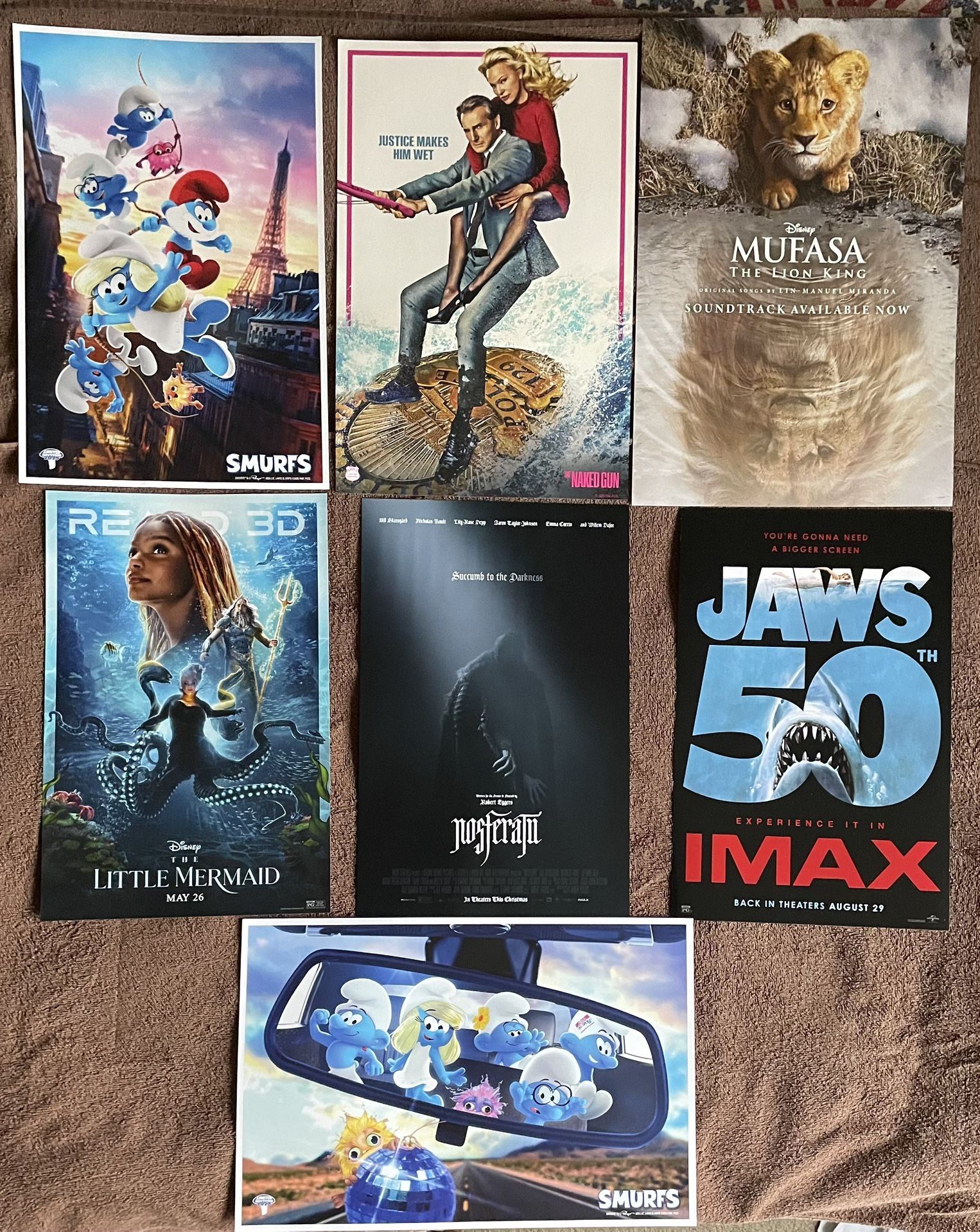 7 Movie Posters: Mufasa The Lion King, Jaws, Nosferatu, The Naked Gun, The Little Mermaid. Smurfs