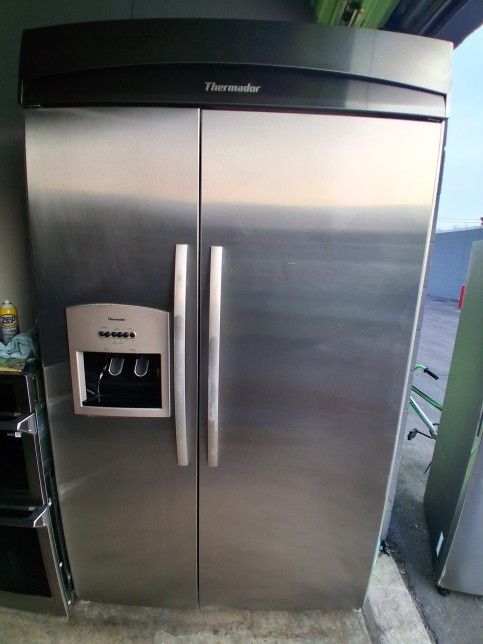 This 48-inch wide refrigerator is in good condition, made by Thermador, and dispenses ice and water.