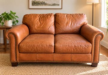 Traditional vinyl loveseat in a rich caramel tan color.