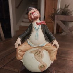 Ceramic Clown sitting on the world.  Spins around playing 'Sitting On Top of the World'.
