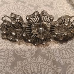 This is a vintage-style metal rhinestone and marcasite flower design hair barrette. 