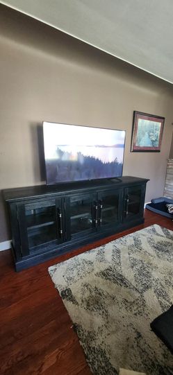 Elegant solid black TV console with 4 door and plenty of storage space.
