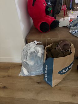 Two bags of women stuff, shoes, dresses shirts. Pants
