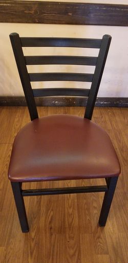 Metal chair with burgundy vinyl seat.