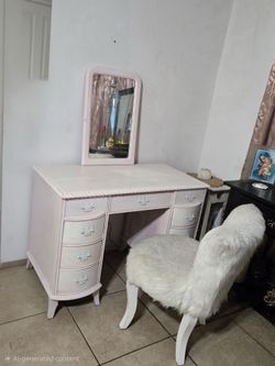 White wood vanity with light pink underneath with mirror and furry chair