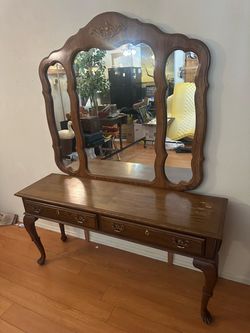traditional oak-finished vanity/dressing desk with a large attached tri-fold mirror, brass hardware, and Queen Anne-style cabriole legs