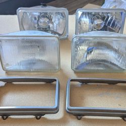 Four  80's Rectangular Headlights And Two Retainers