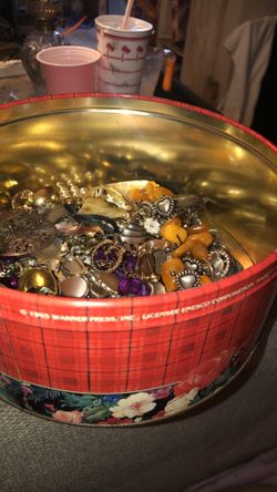 A tin full of costume some old costume jewelry