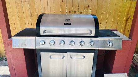 6 burner Dyna-Glo stainless steel liquid propane gas grill equipped with a side burner
