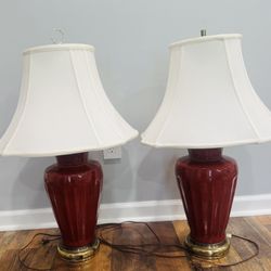 A pair of vintage table lamps with ceramic bases in the "sang de bœuf" (oxblood) glaze technique.
