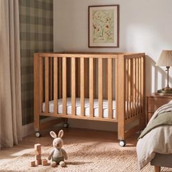 Brand new/in box mini crib, mattress, sheets