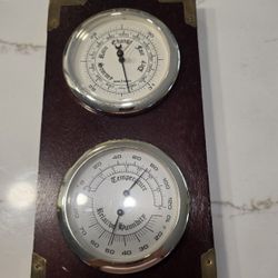 Barometer and thermometer with hygrometer on a mahogany wood base. Measures 12.5 inches high x 6 inches wide