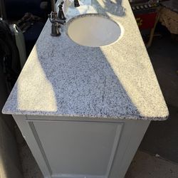 Great condition gray bathroom vanity with granite countertop and round sink. Has multiple drawers and a cabinet door. Faucet is included. Granite top 