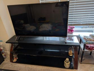 Table — $100 (Category: Furniture)
Title: 3-Tier Black Glass TV Stand with Wood Sides - Good Condition