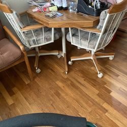 Dining table with four rolling chairs.