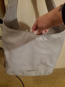 Used Michael Kors purse, light grey color, has a lil wear on the under side of strap. Overall good condition! 60$